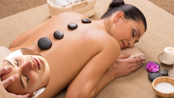 Mulher relaxando em maca durante massagem linfática para desinchar pernas